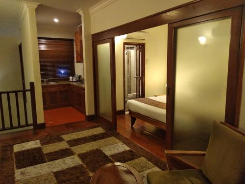 a room with a bedroom with a bed and a couch at Langkawi Lagoon Resort Water Chalet in Pantai Cenang