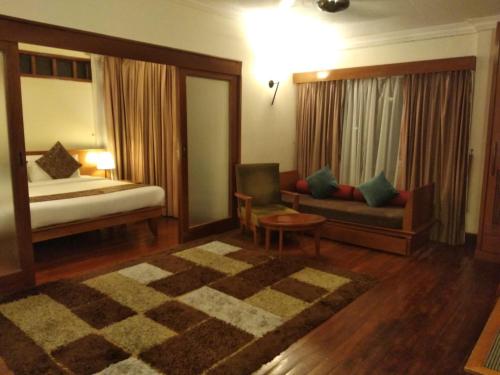 a hotel room with a bed and a couch at Langkawi Lagoon Resort Water Chalet in Pantai Cenang