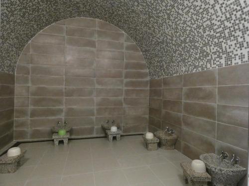 a bathroom with three urinals in a tile wall at Le Zenith Hotel Oran in Oran