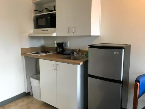 a small kitchen with a sink and a refrigerator at Studio 6-Fayetteville, NC - Fort Liberty Area in Fayetteville