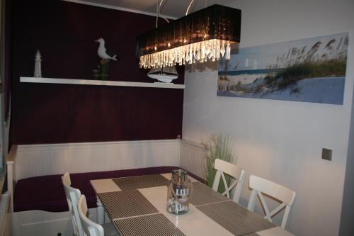 a dining room with a table and a chandelier at Koserow Ferienwohnung Fam. Jäger 400m zum Strand in Ostseebad Koserow