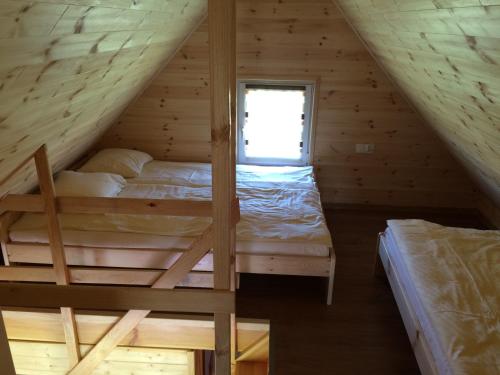 a bedroom in a log cabin with two bunk beds at Domki na Morskiej in Łukęcin