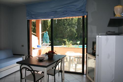 a kitchen with a table with chairs and a refrigerator at Verdemare Sardegna Uno in Villasimius