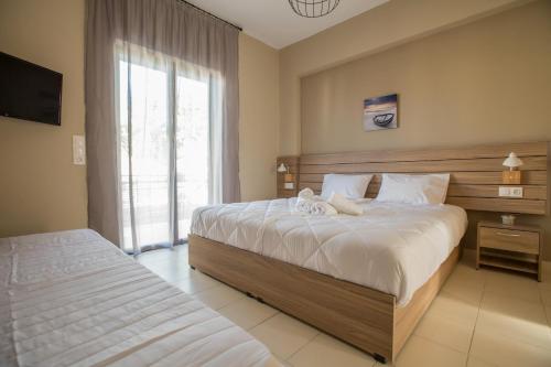 a bedroom with two beds and a large window at Ilaeira rooms in Argassi