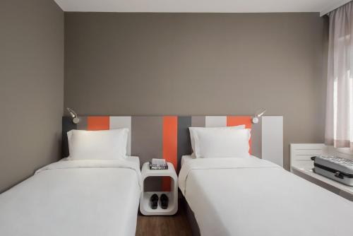 two beds in a small room with two beds sidx sidx sidx at Intercity Ribeirão Preto in Ribeirão Preto