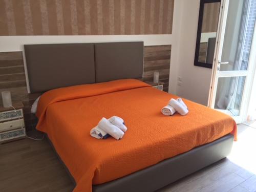 - 2 serviettes sur un lit avec une couverture orange dans l'établissement Monolocale Mulino, à Favignana