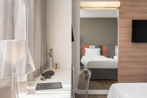a hotel room with a bed and a mirror at Intercity Ribeirão Preto in Ribeirão Preto