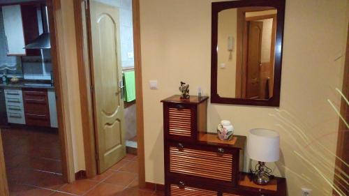 a room with a mirror and a table with a lamp at Casa Maricarmen in Camariñas
