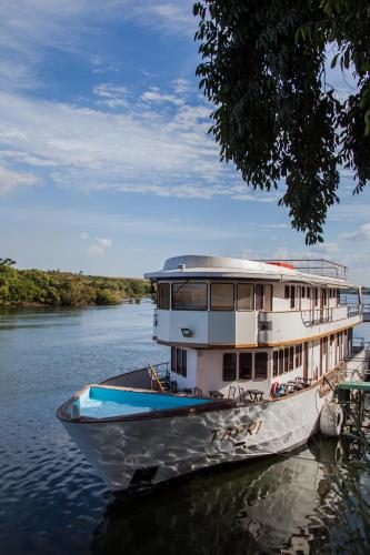 a boat is docked on a river at Tapri - Hotel Flutuante in Barra Bonita