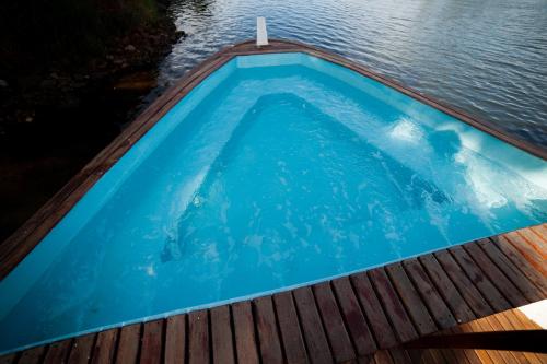 een zwembad op een terras naast het water bij Tapri - Hotel Flutuante in Barra Bonita