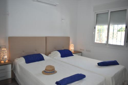 two beds with hats on top of them in a bedroom at Villa Esmeralda in Estepona