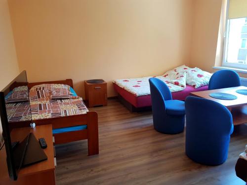 Cette chambre comprend deux lits, une table et des chaises. dans l'établissement Pokoje goscinne ''Muszelka'', à Świnoujście