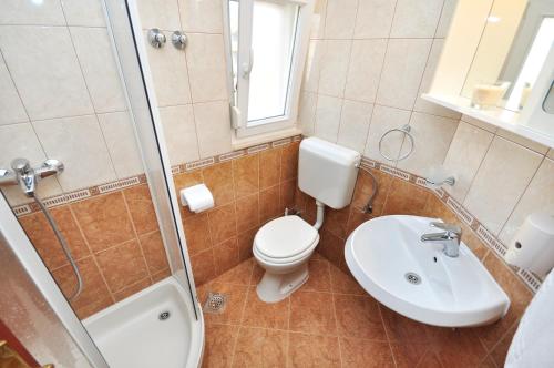 a bathroom with a toilet and a sink and a shower at Apartment House Jerko in Kaštela
