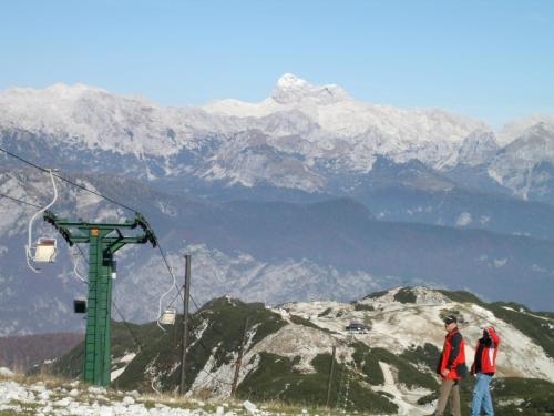 two people standing on top of a mountain with a ski lift at Snežak (Snowman) 2 in Bohinj