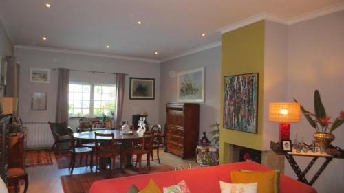 ein Wohnzimmer mit einem roten Sofa und einem Tisch in der Unterkunft A Casa do Lagar in Azeitão