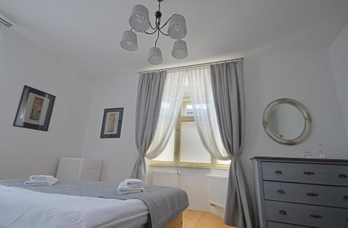 a bedroom with a bed and a mirror and a window at 1st Republic Villa - Adults only in Český Krumlov