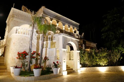 a white building with flowers in front of it at night at Villa Angelina in Selva di Fasano