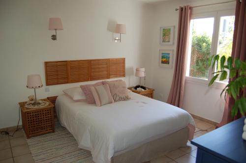 a bedroom with a white bed and a window at La Maison de Peggy in Garons