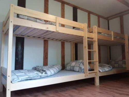 two bunk beds in a room with a bed at Zbójnicki Ostęp-Nocleg Trapera in Kletno