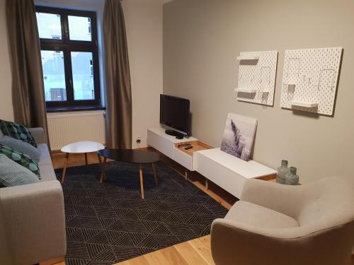 a living room with a couch and a tv at The Gusto apartmán in Chomutov