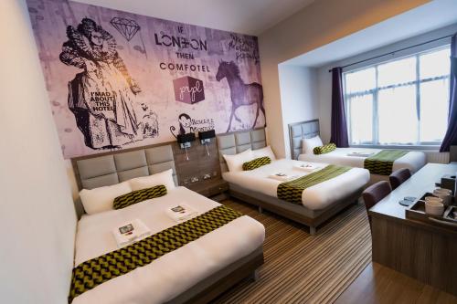 a room with three beds and a wall with a mural at Comfotel PRPL in London