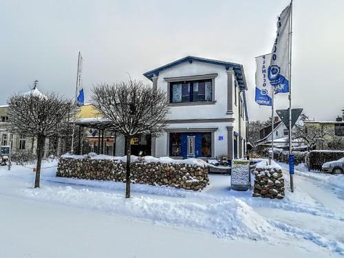 a house with snow on the ground in front of it at Koserow Ferienwohnung Fam. Jäger 400m zum Strand in Ostseebad Koserow