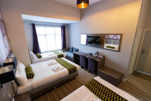 a small room with two beds and a television at Comfotel PRPL in London