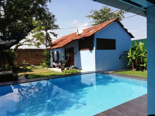 a villa with a swimming pool in front of a house at Coco Country Homes in Melaka