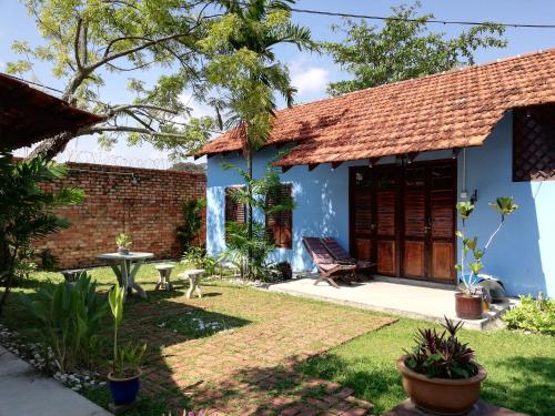 a house with a blue facade and a yard at Coco Country Homes in Melaka