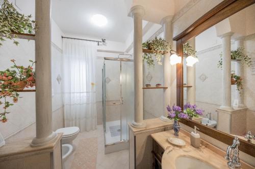 a bathroom with a shower and a sink and a toilet at Appartamento Rosa in Cefalù