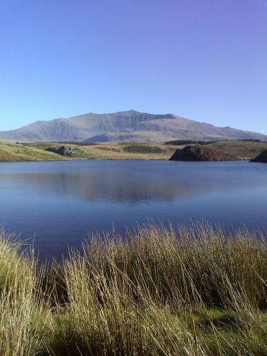 a large body of water with mountains in the background at Samuel cottage in Caernarfon