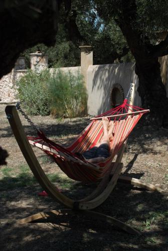 a person sitting in a hammock under a tree at LIORIZA Country Houses in Kalamaki