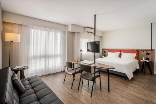 ポルト・アレグレにあるIntercity Porto Alegre Praia de Belasのベッドとデスクが備わるホテルルームです。