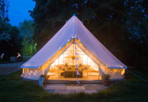 a large white tent with lights in a yard at Oxford Riverside Glamping in Oxford