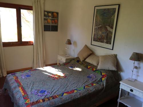 a bedroom with a bed with a colorful quilt on it at Casa Higuera en MonteGrande in Monte Grande