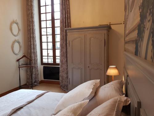 a bedroom with a bed with white sheets and a window at Hotel Particulier Robin Quantin in Tours