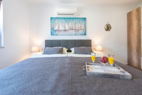 1 dormitorio con 1 cama con 2 vasos de zumo de naranja en Apartments Villa Elena 2, en Cavtat