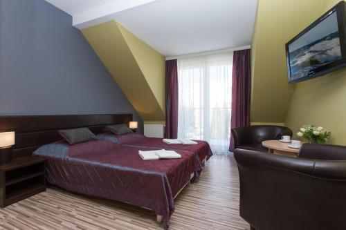 a hotel room with a bed and a couch at NA BIAŁEJ in Rewal