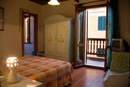 sypialnia z łóżkiem oraz balkon z telewizorem w obiekcie B&B Vecchia Alghero w mieście Alghero