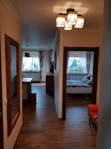 a room with a bedroom with a bed and a mirror at Przytulny Zakątek in Piła