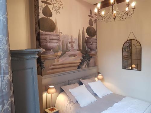 a bedroom with a bed and a chandelier at Hotel Particulier Robin Quantin in Tours