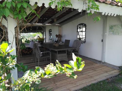 a patio with a table and chairs on a wooden deck at Wiejska Chata in Szwalk