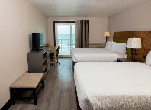 Habitación de hotel con 2 camas y balcón en Garden City Inn, en Myrtle Beach