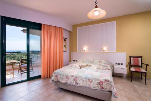 a bedroom with a bed and a balcony at Ocean Beach Hotel in Skala Potamias