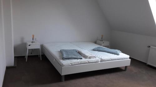 a white bed with two towels on top of it at Haus am Hafen in Leer