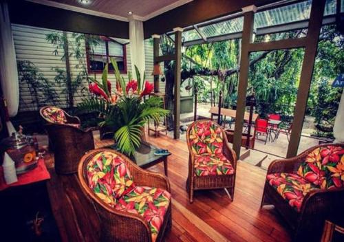 a living room with chairs and a table with flowers at Hotel Aranjuez in San José