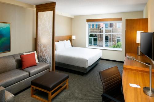 a hotel room with a bed and a couch at Hyatt Place Sumter/Downtown in Sumter