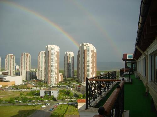 a rainbow over a city with tall buildings at Hotel Monec in Ankara