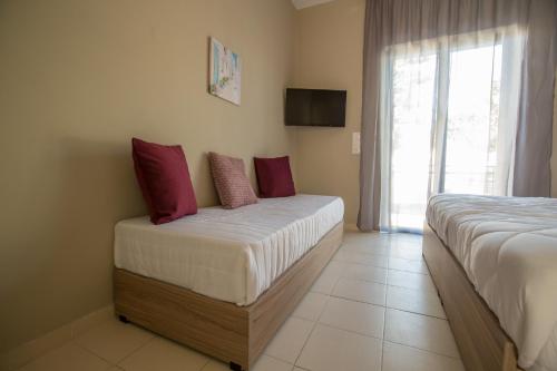 a hotel room with two beds and a window at Ilaeira rooms in Argasi