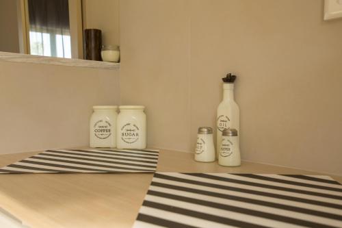 three white bottles sitting on top of a counter at Ilaeira rooms in Argasi
